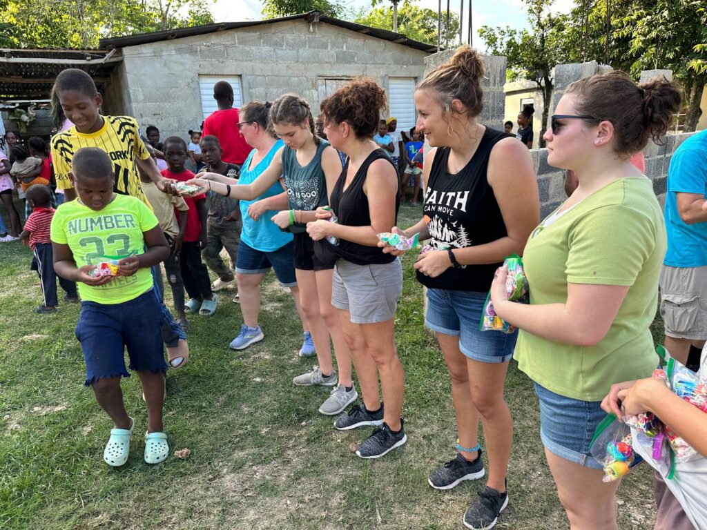 Handing out candy to the children at the sugar cane village